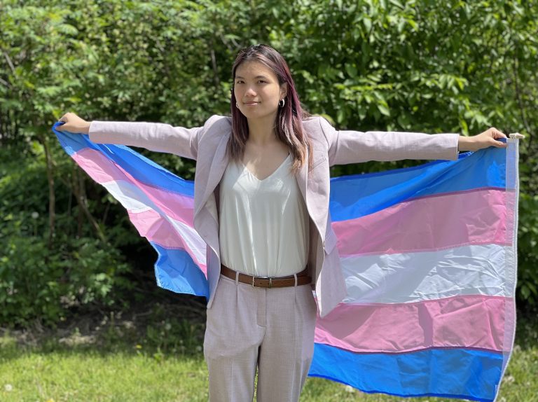 Celeste Trianon poses with a Trans pride flag.